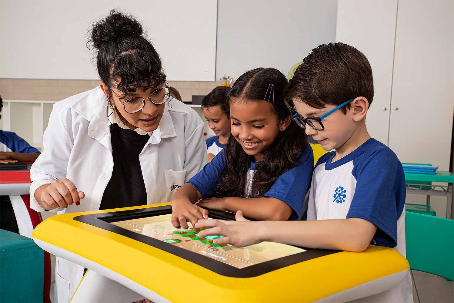 Professora acompanhando crianças na PlayTable